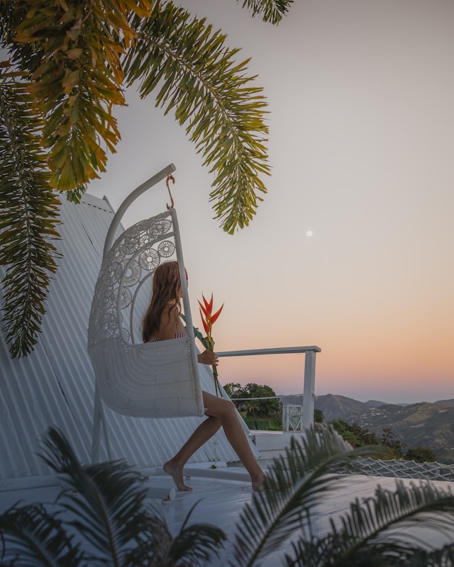 Woman on a hanging chair enjoying the sunset during a private immersion